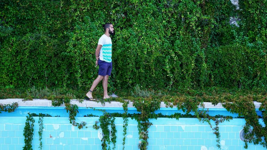 Full length of man standing by swimming pool