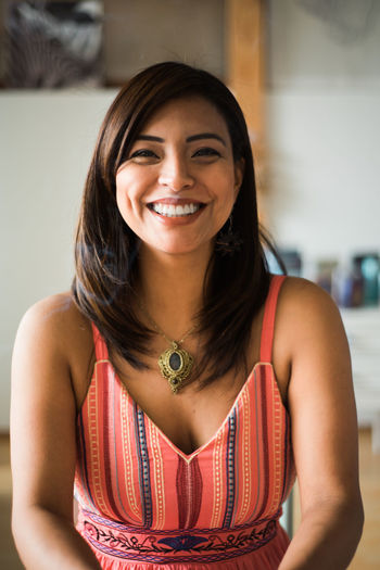 Portrait of young woman standing at home