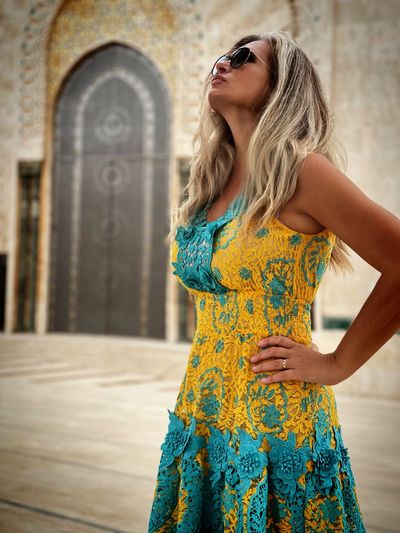 Portrait of young woman standing against wall
