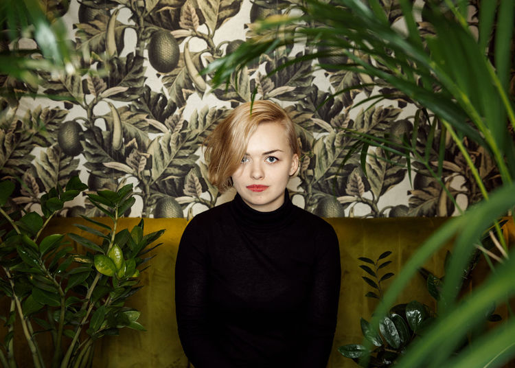 Portrait of woman sitting by plants