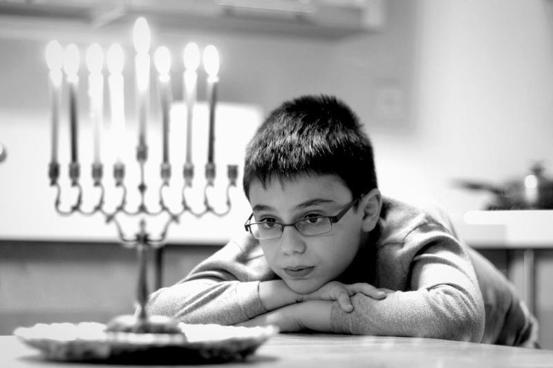 Close-up of boy looking at candlestick