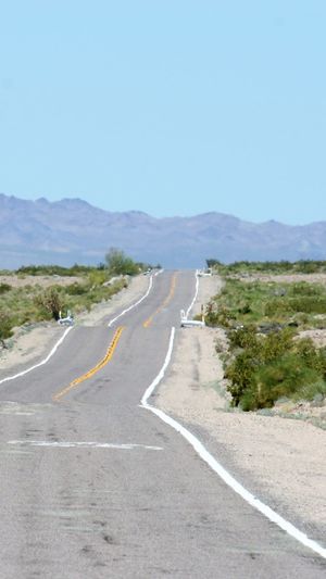 Empty road on landscape against clear sky