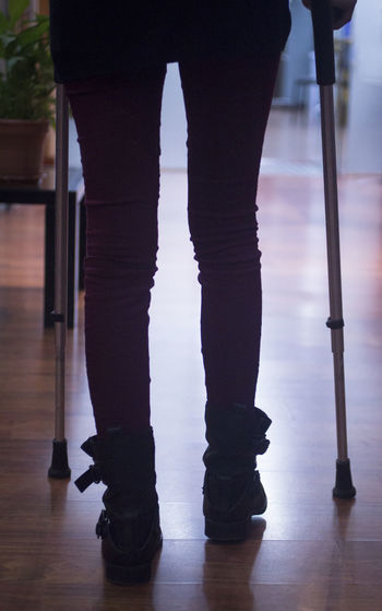 Low section of person walking with crutches
