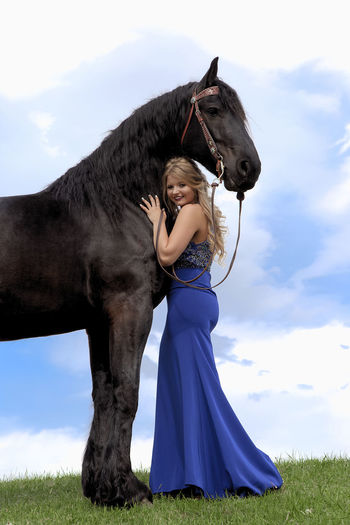 Portrait of woman embracing horse while standing outdoors