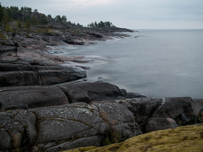 Scenic view of rocky beach against sky