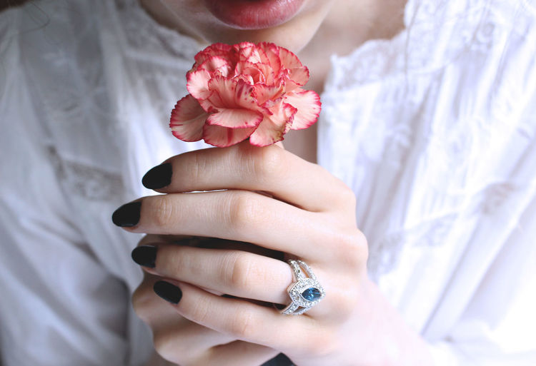 Midsection of woman holding carnation flower