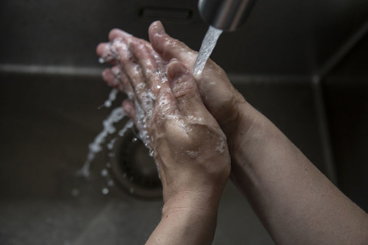 Close up of someone rinsing hands in the sink