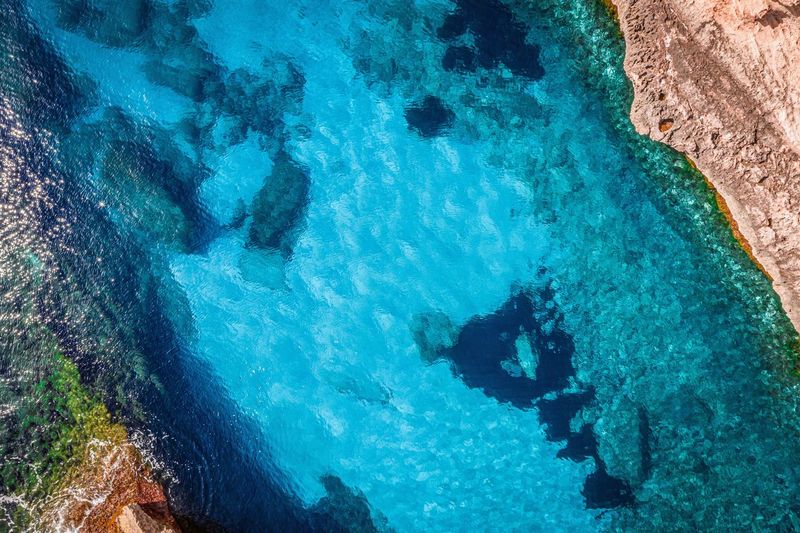 Crystal clear blue sea with rocks. view from above