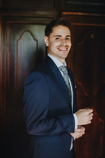 Portrait of smiling young man standing at home