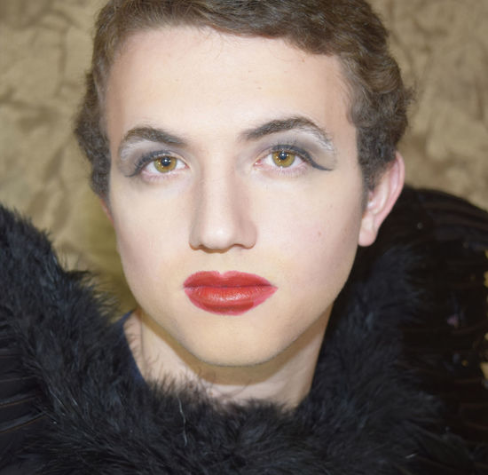 Close-up portrait of young man with red lipstick