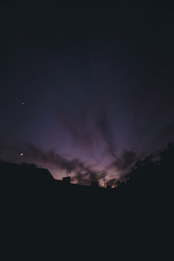 Low angle view of silhouette landscape against sky at night