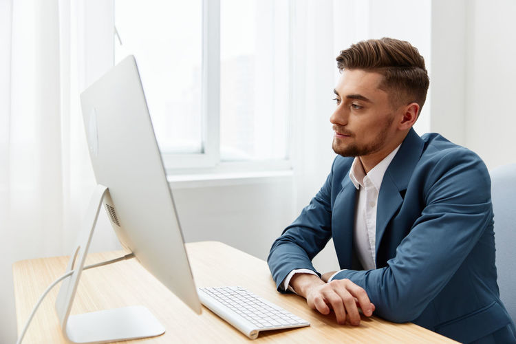 Side view of businessman using laptop at office