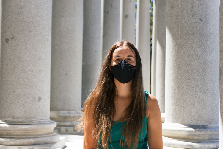Portrait of young woman wearing mask standing outdoors