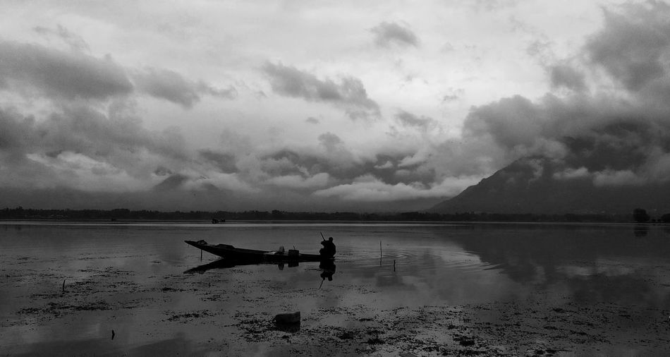 Silhouette people on boat at lake against sky dal lake kashmir