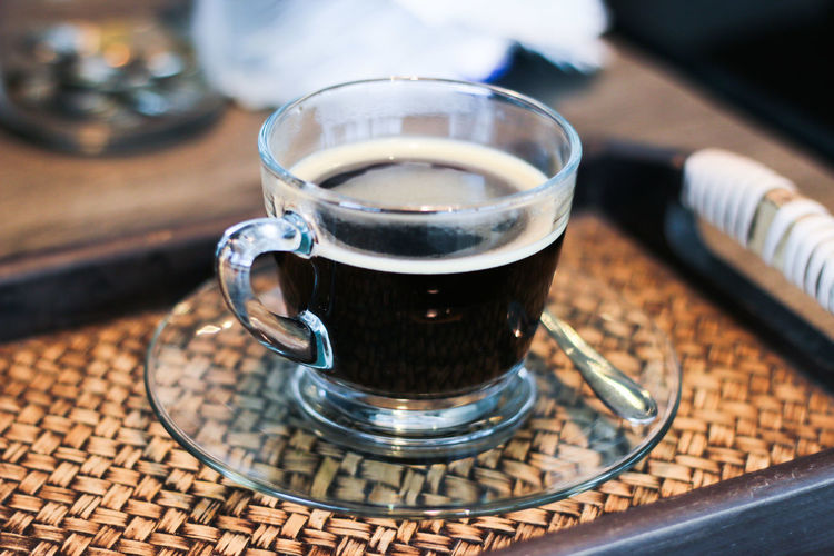 Close-up of cup of black coffee served in glass cup