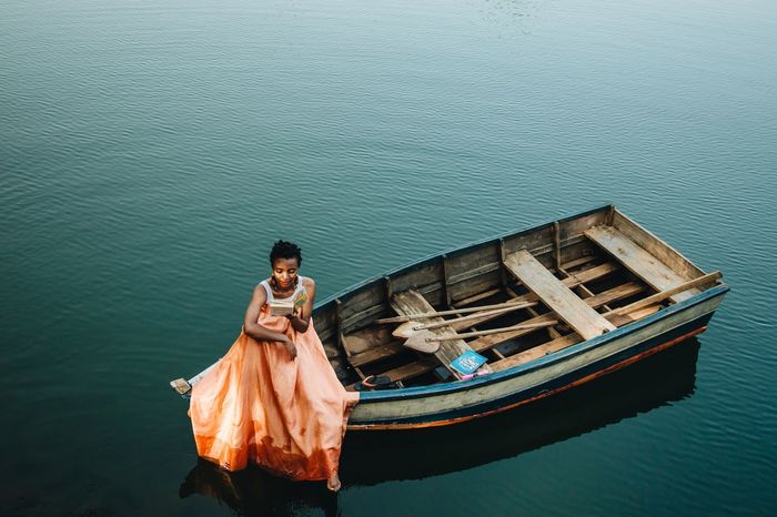 High angle view of woman sitting on boat in sea