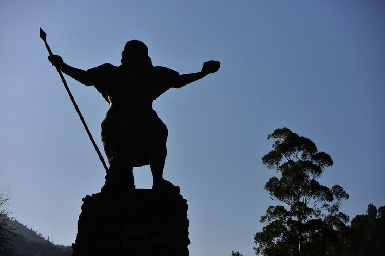 Low angle view of statue against blue sky.
monument to the indian