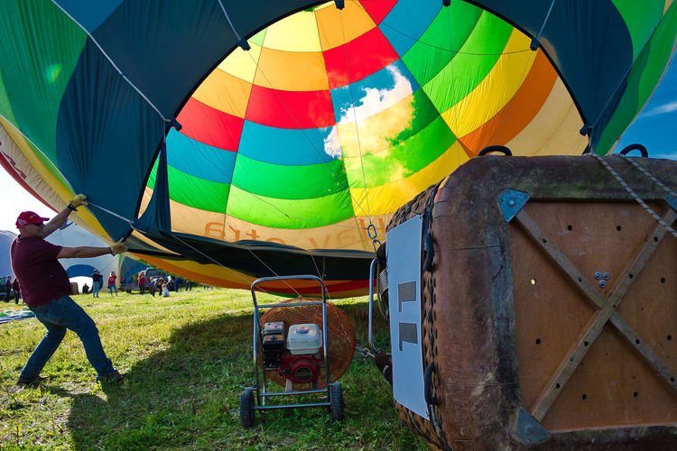 Rear view of hot air balloons on field