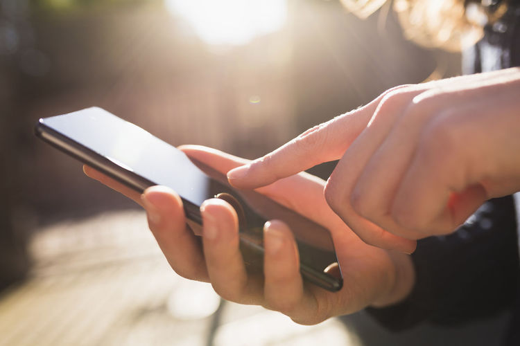 Woman's finger touching display of smartphone