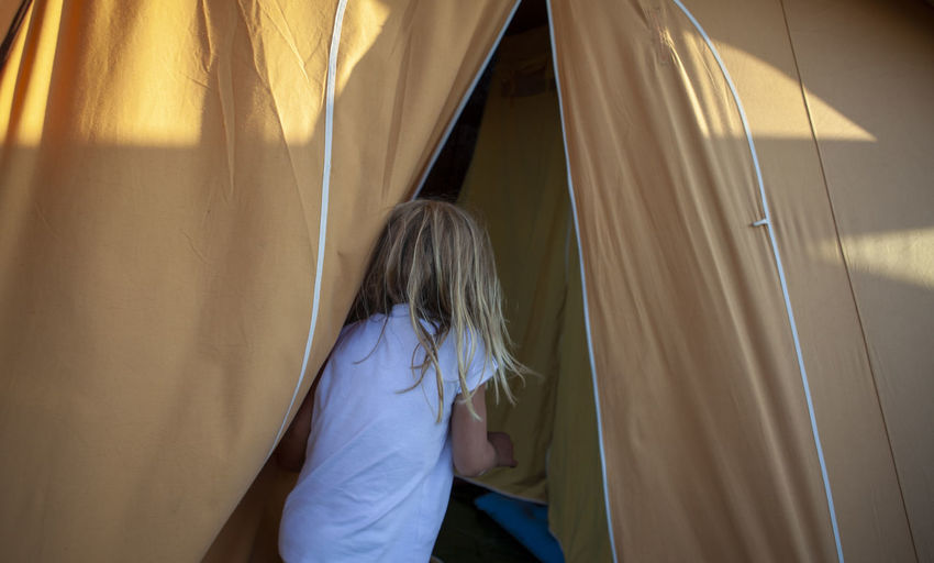 Rear view of girl in tent at home