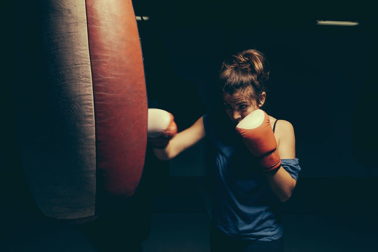 Female boxer exercising at punch bag