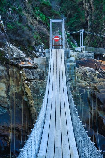 Suspension bridge at storm river mouth, south africa with no through traffic sign