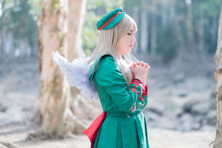 Side view of woman in angel costume standing outdoors