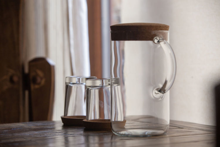 Close-up of drinking glasses with jug on table