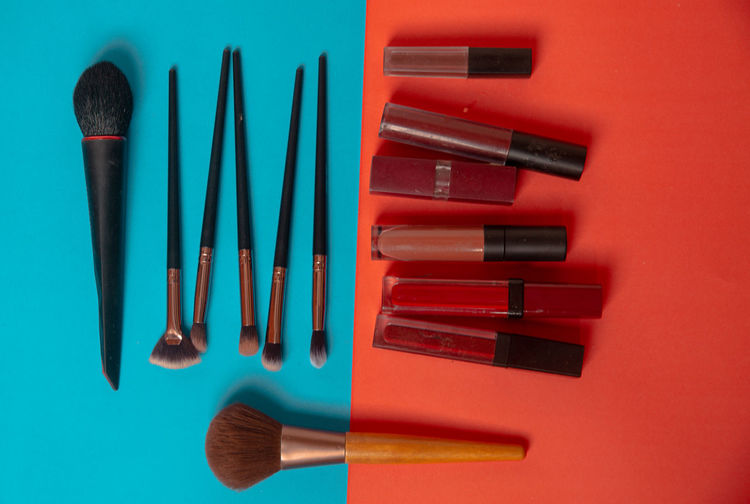 High angle view of make-up brushes on yellow background