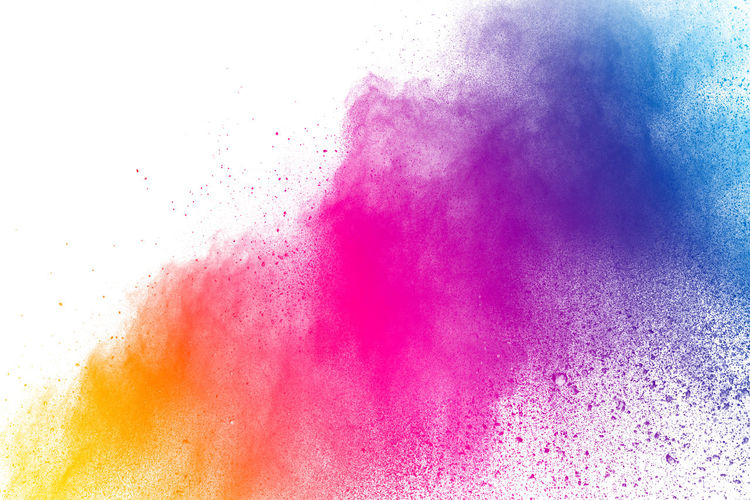 Defocused image of multi colored powder paints against white background