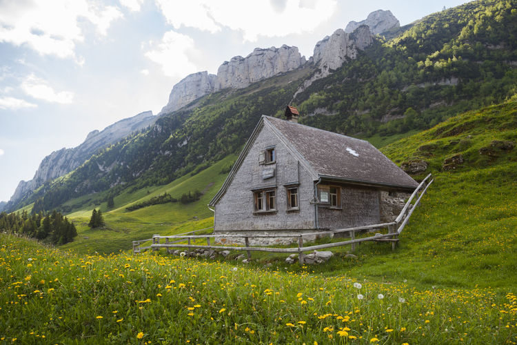 Alpine hut below limestone spires in alpstein, appenzell, switzerland