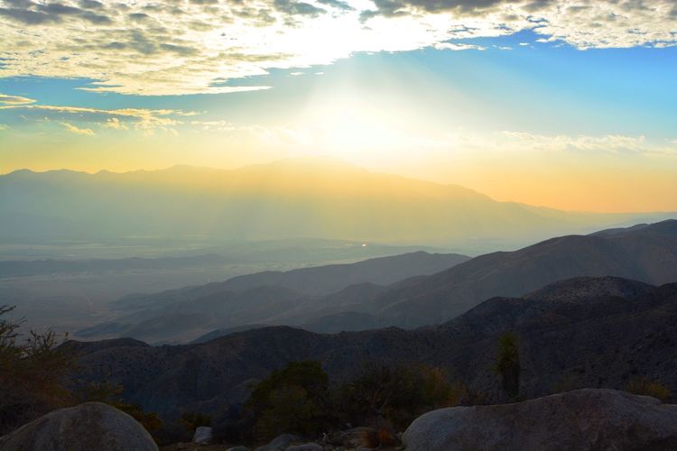 Scenic view of mountains against cloudy sky during sunset at joshua tree national park