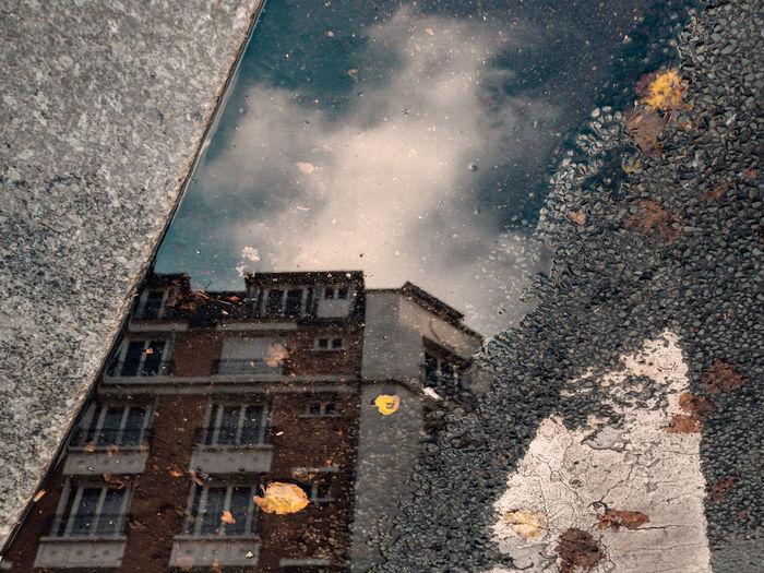 Reflection of buildings in puddle on street