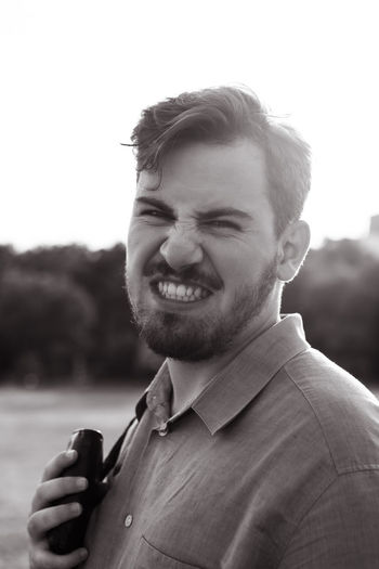 Portrait of young man standing against sunset. happy and angry male outdoors. emotional