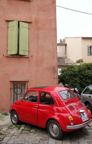Red vintage car outside building