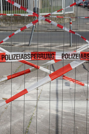 Cordon tape behind fence on street