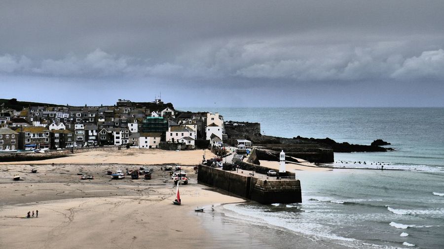 St ives town by sea against cloudy sky