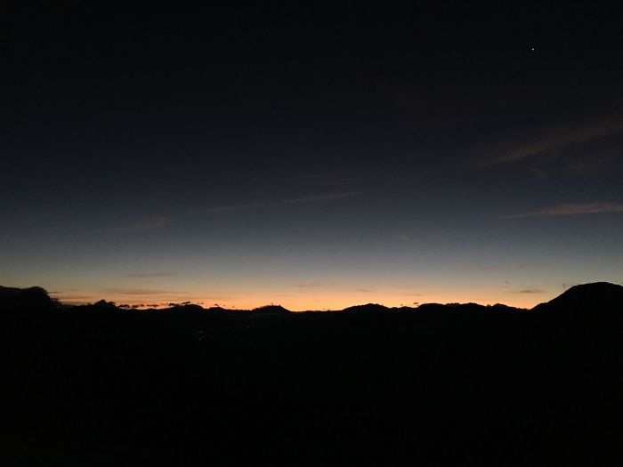 Scenic view of silhouette mountains against sky at sunset
