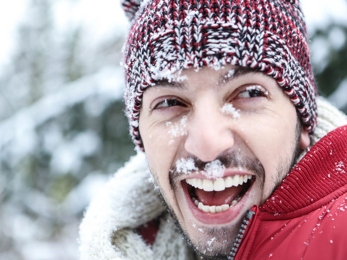 Close-up of cheerful man looking away during winter