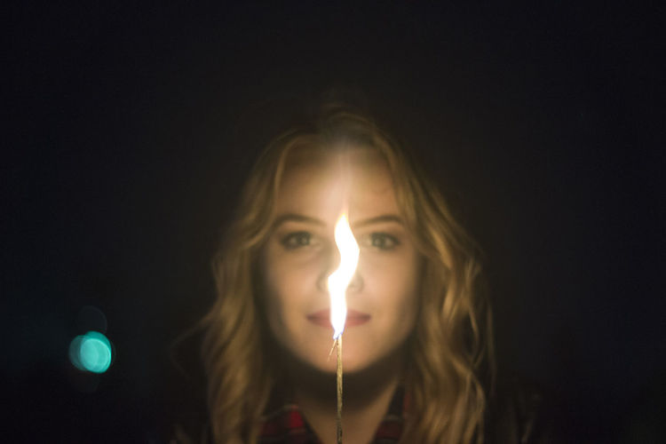 Close-up portrait of woman with light painting at night