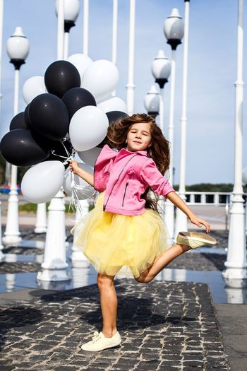 Full length of a smiling girl with balloons
