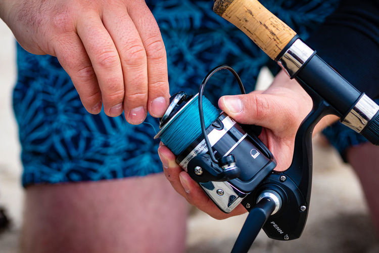 Midsection of man holding fishing rod