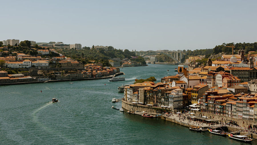 High angle view of sea amidst townscape against clear sky
