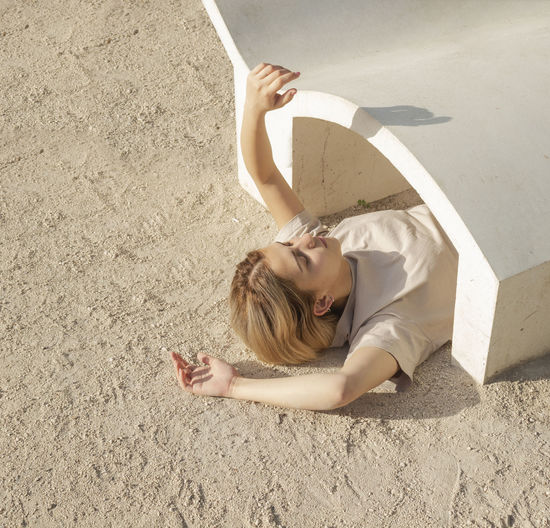 High angle view of woman lying down on sand