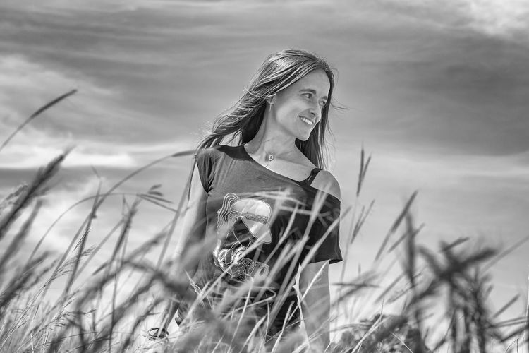 Woman standing on field against sky