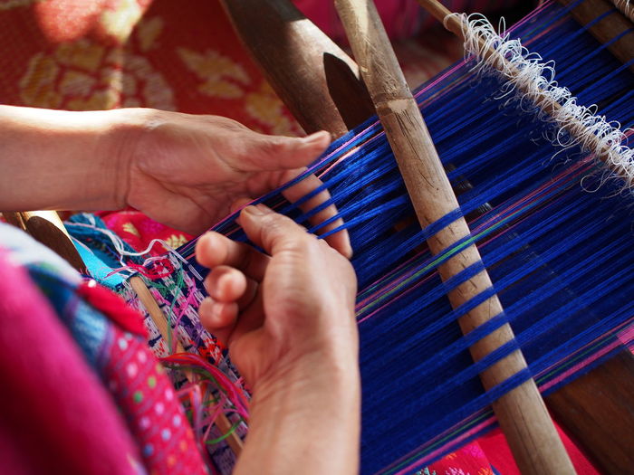 Midsection of woman working on loom