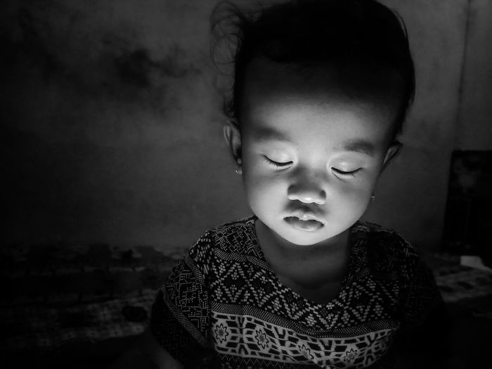 Close-up of cute little girl looking away