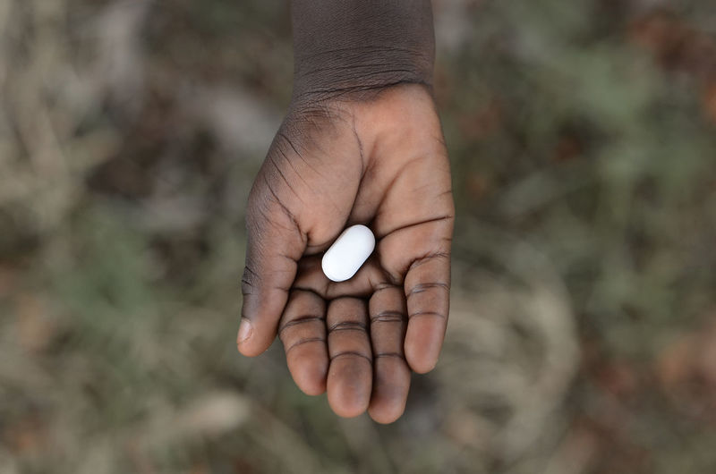 Cropped hand of child holding medicine