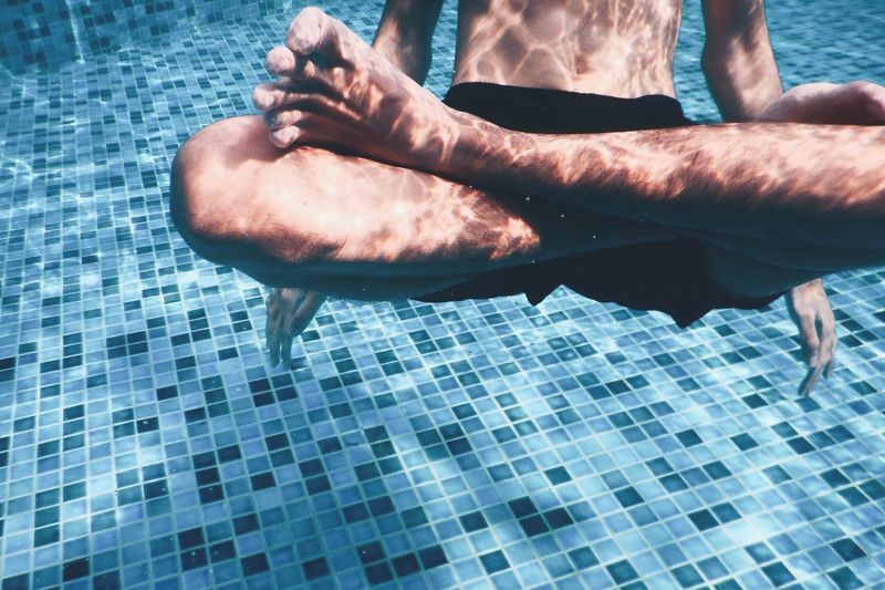 Man with crossed legs in swimming pool