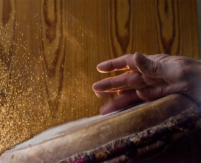 Cropped hand of musician banging drum